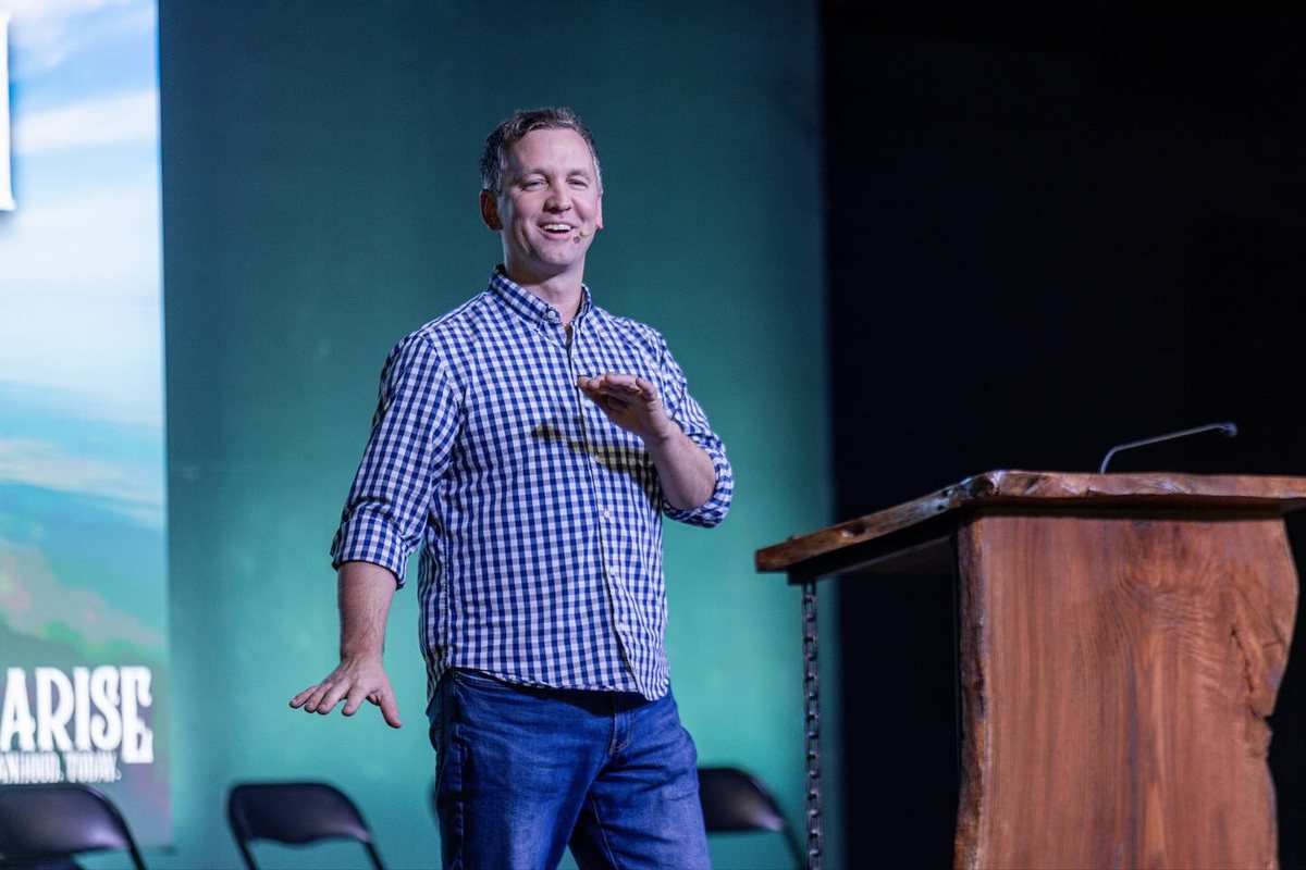 Darrell speaking on stage at a Men Arise event